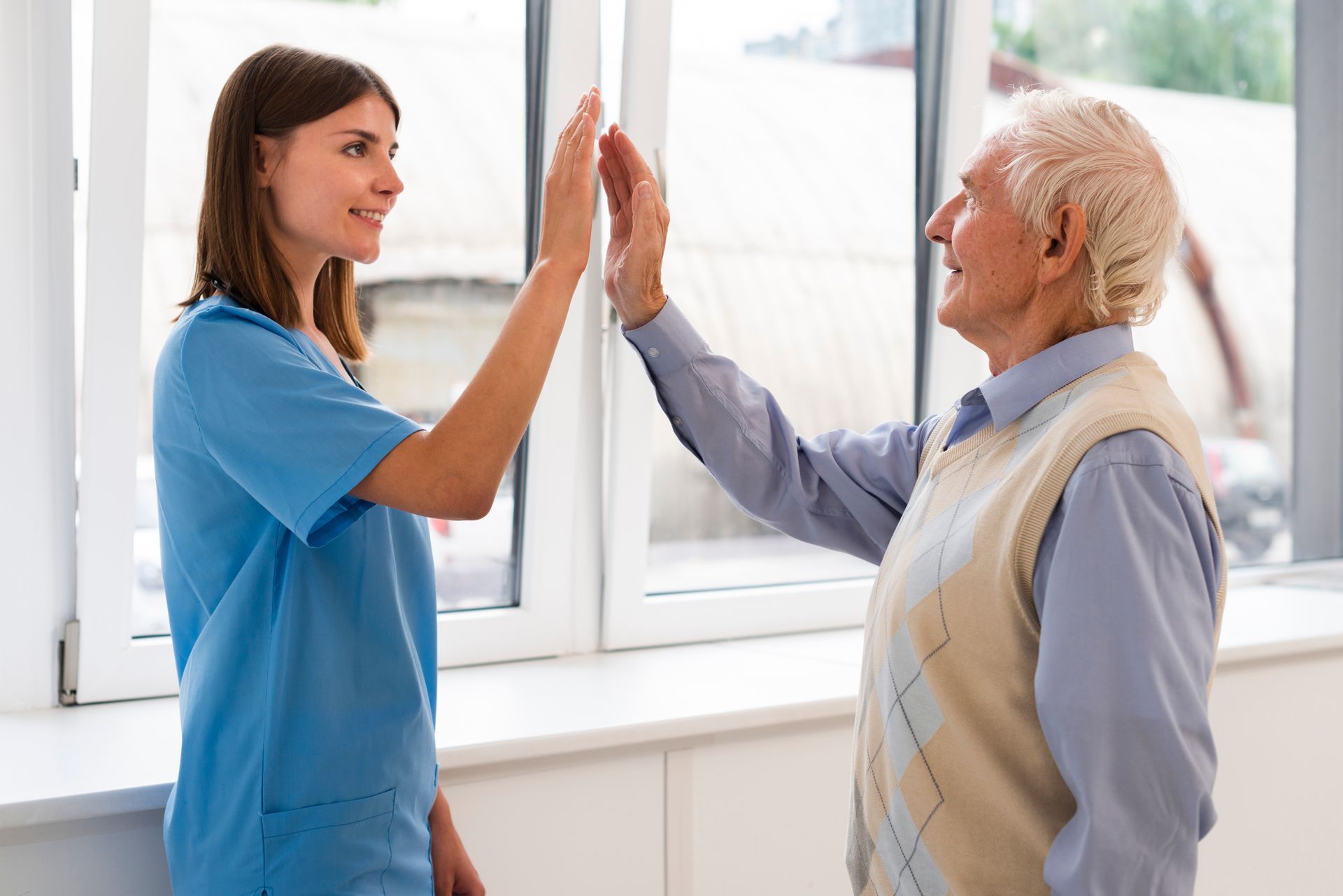 Caregiver high-fiving a senior resident