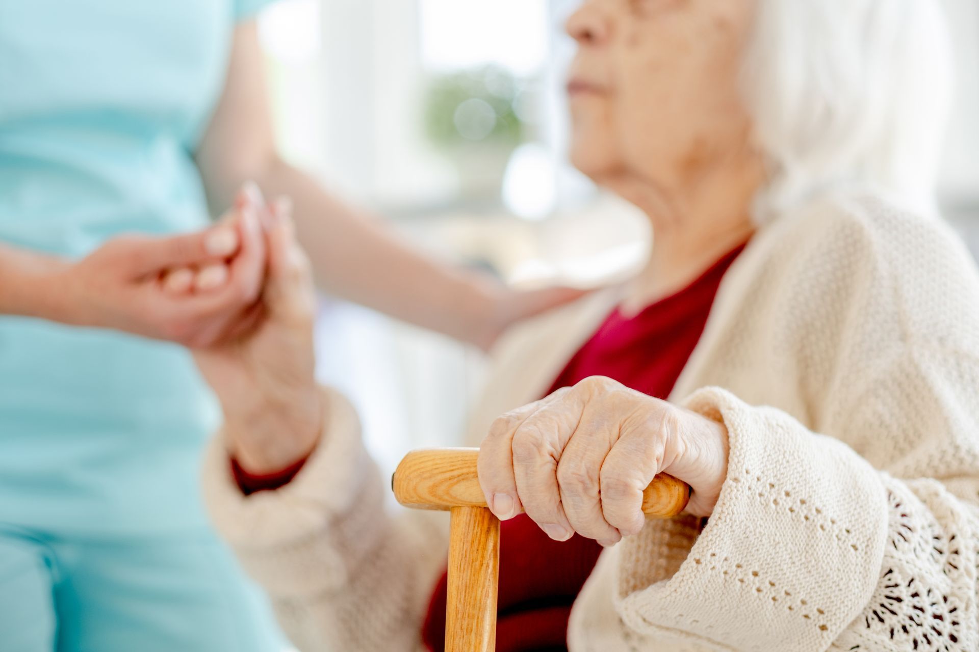 Nurse holding an elderly resident's hand